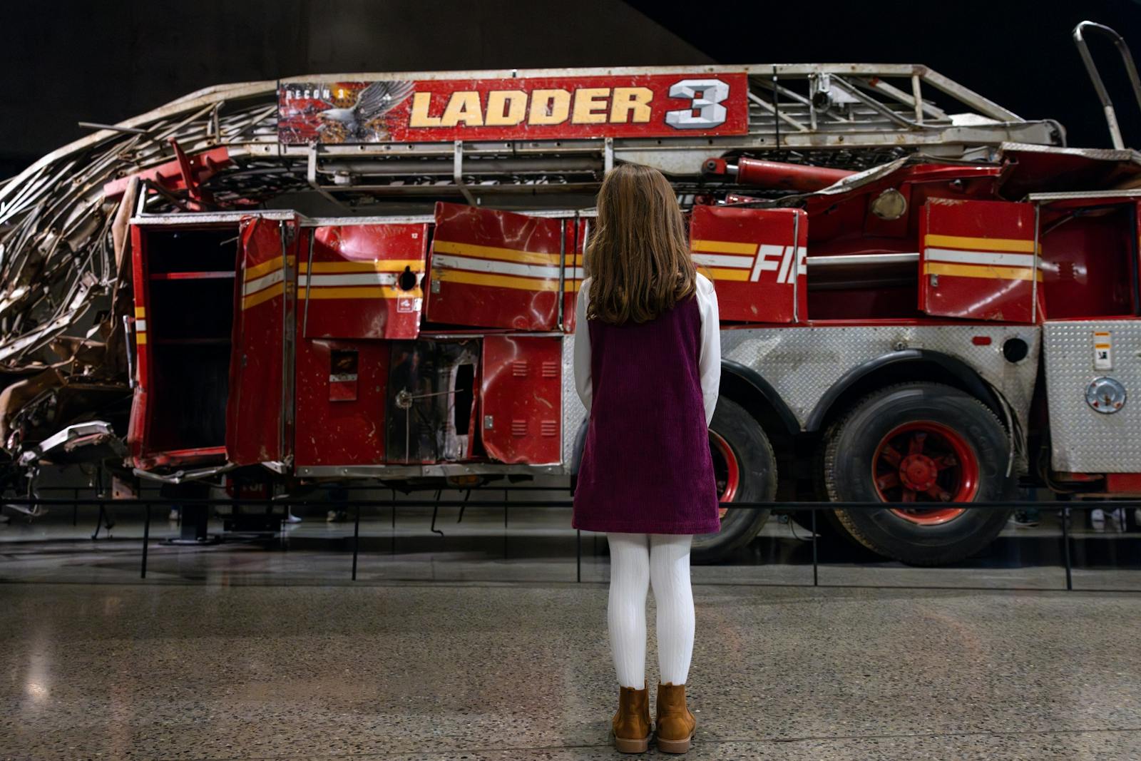 Young girl contemplates Ladder Company 3 truck at the 9/11 Memorial & Museum