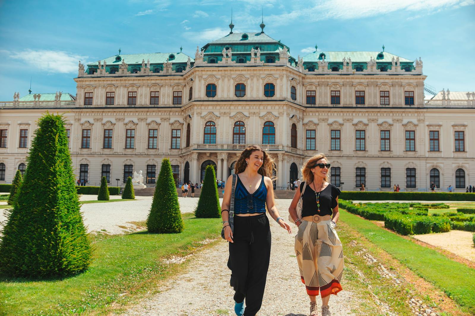 Dos mujeres caminan alegremente frente al Palacio del Belvedere