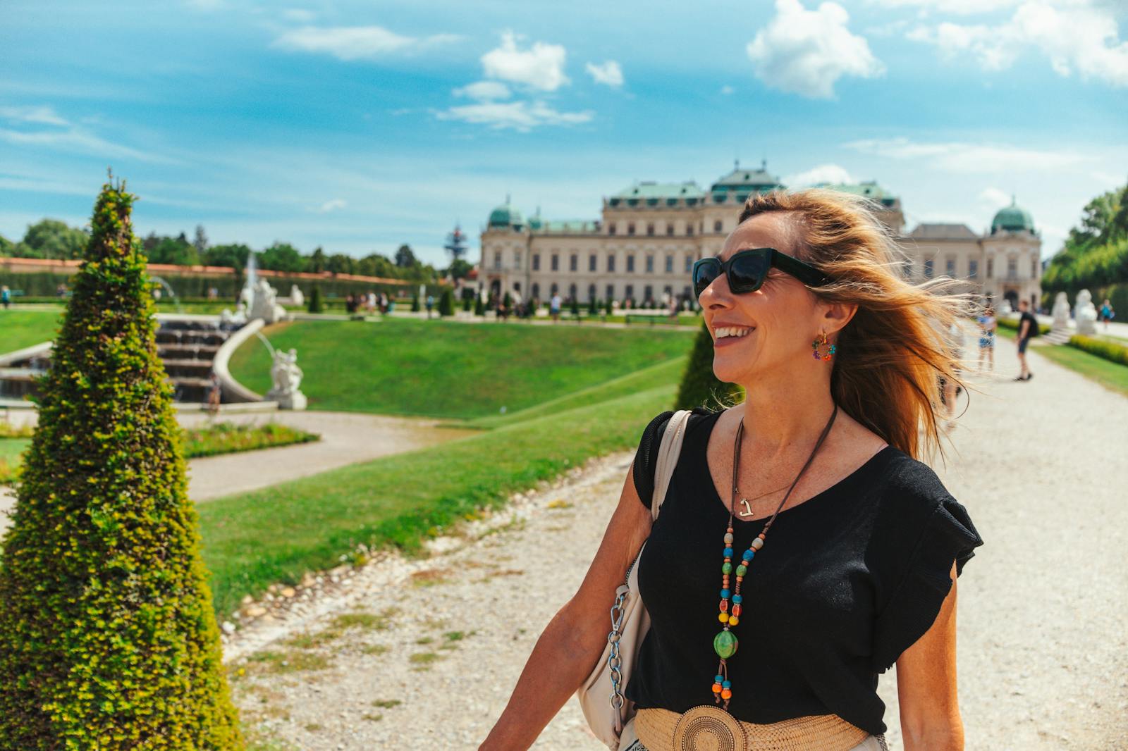 Femeie zâmbind în fața Palatului Belvedere însorit