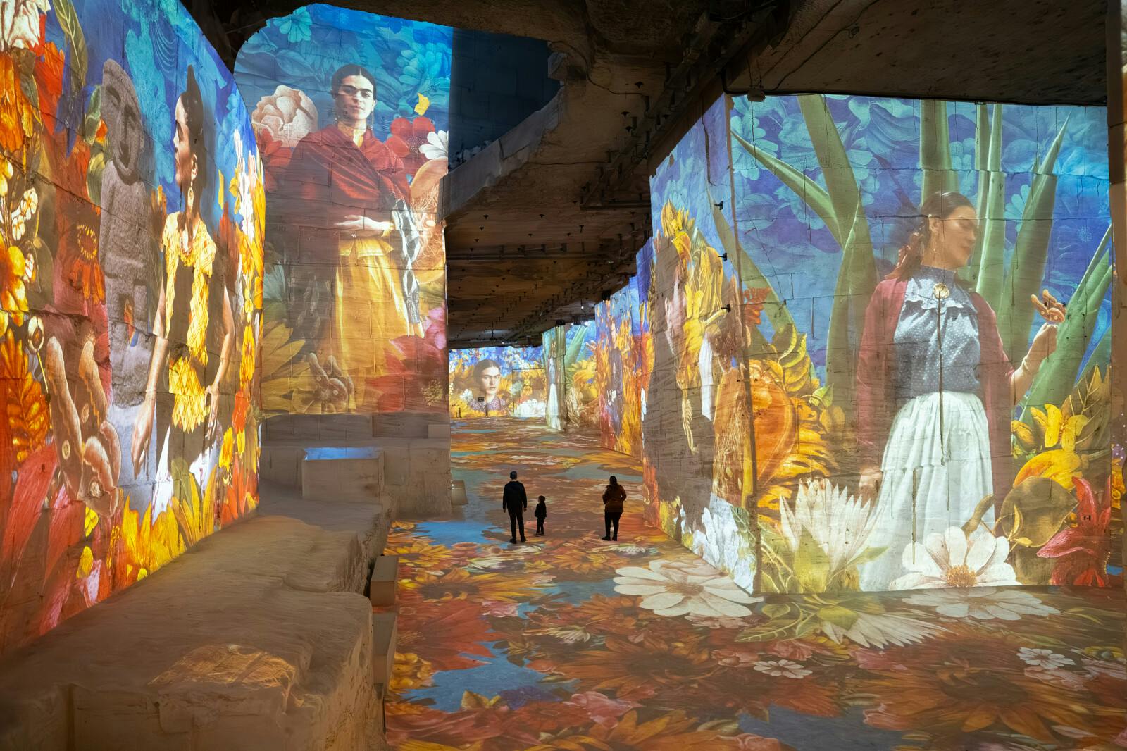 Návštěvníci chodící v Carrières des Lumières pod projekcemi