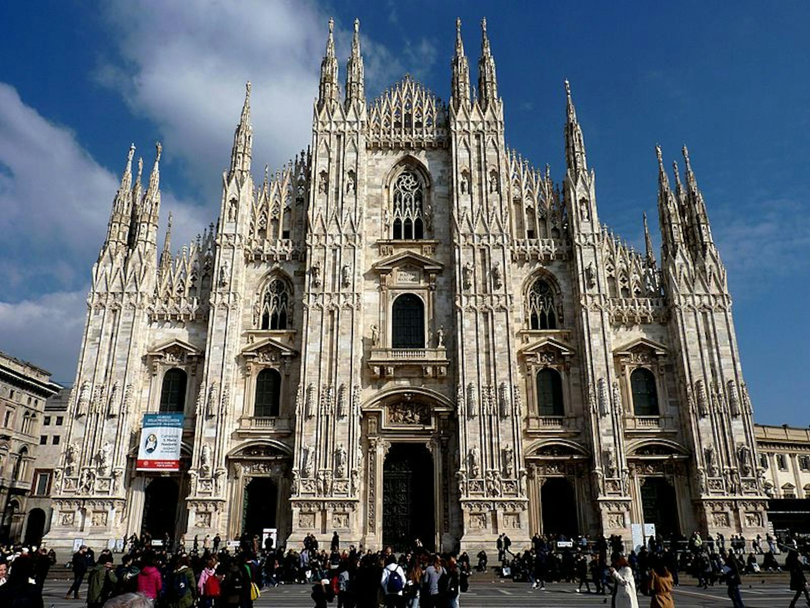 Il Duomo di Milano visto di fronte sotto un cielo azzurro