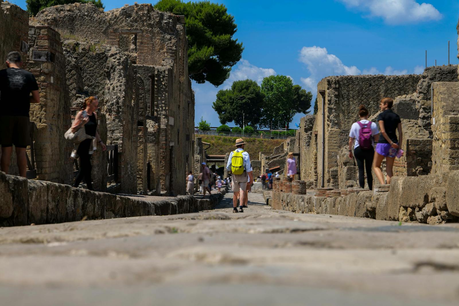 Visitors walking on the ancient cobblestone street of Herculaneum