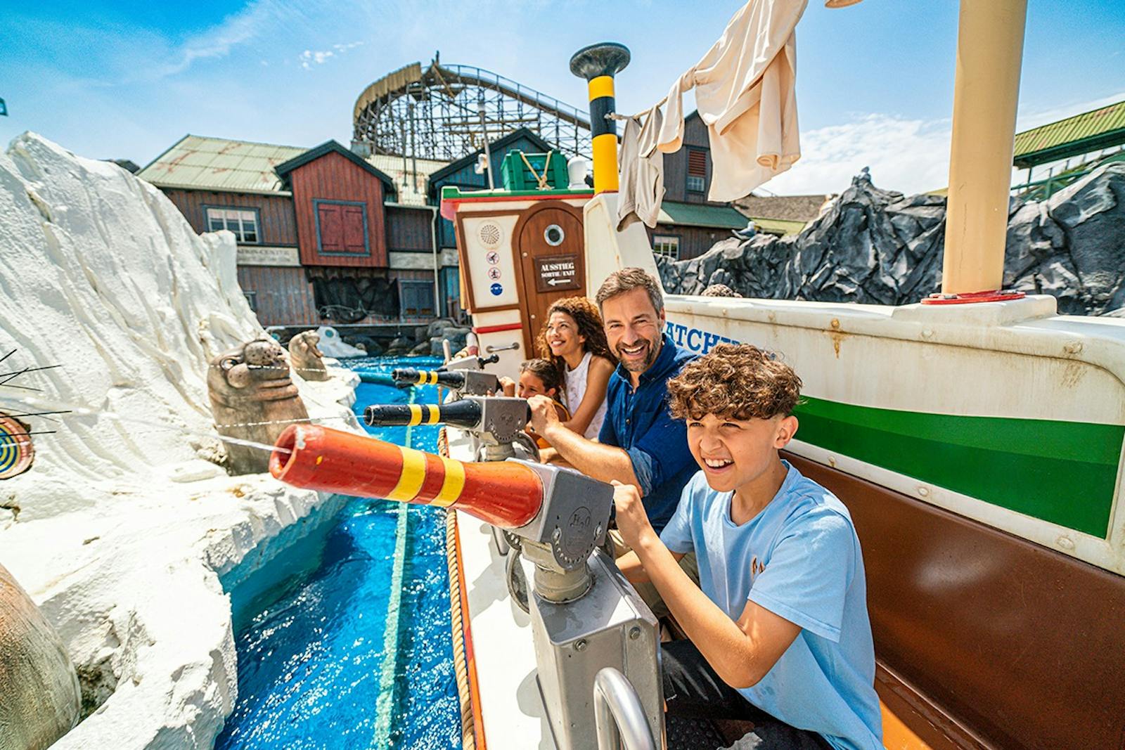 Smilende familie på vannattraksjon i Europa-Park