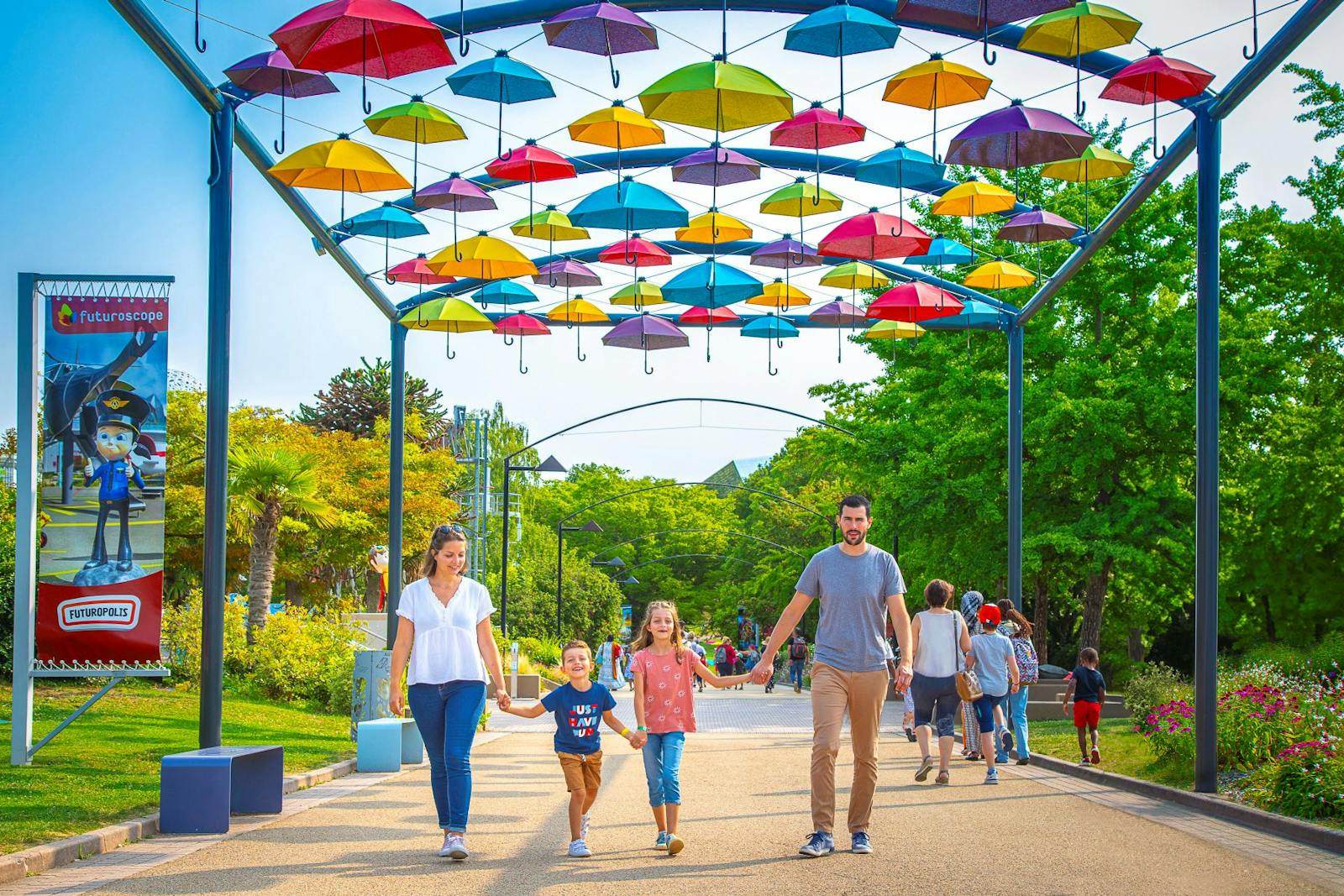 Család sétál a Futuroscope színes esernyői alatt