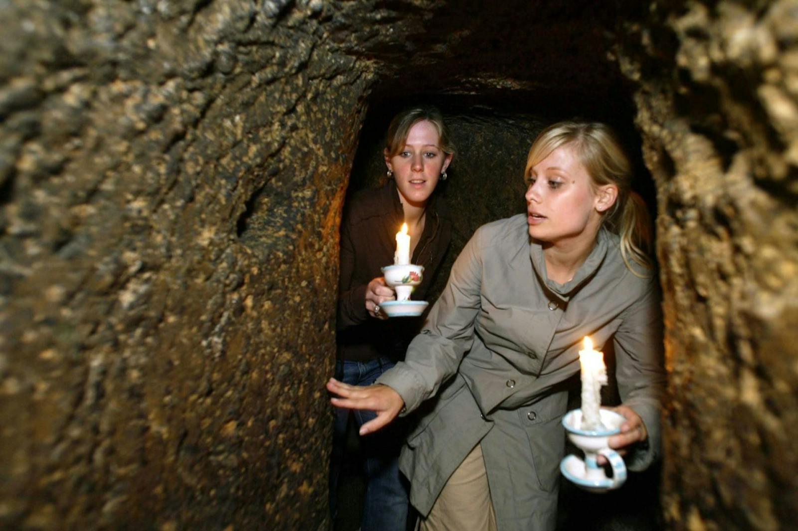 Visiteuses éclairant les Souterrains de Naples avec des bougies