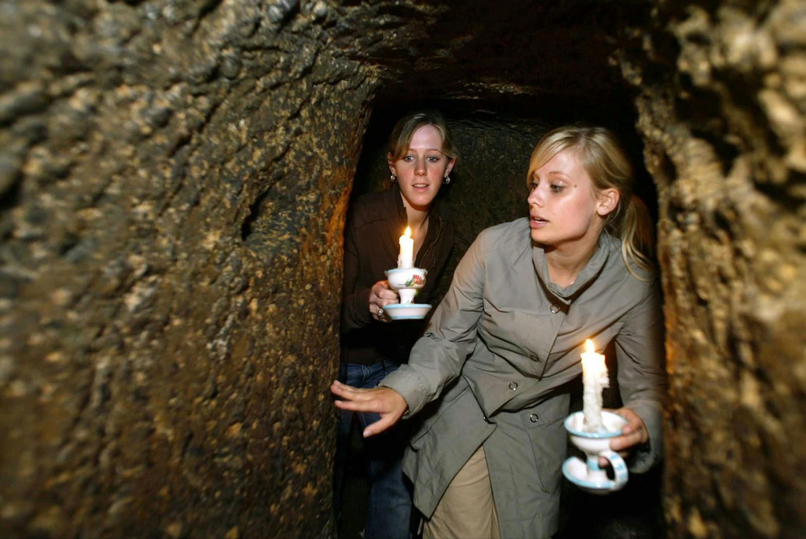 Visiteuses éclairant les Souterrains de Naples avec des bougies