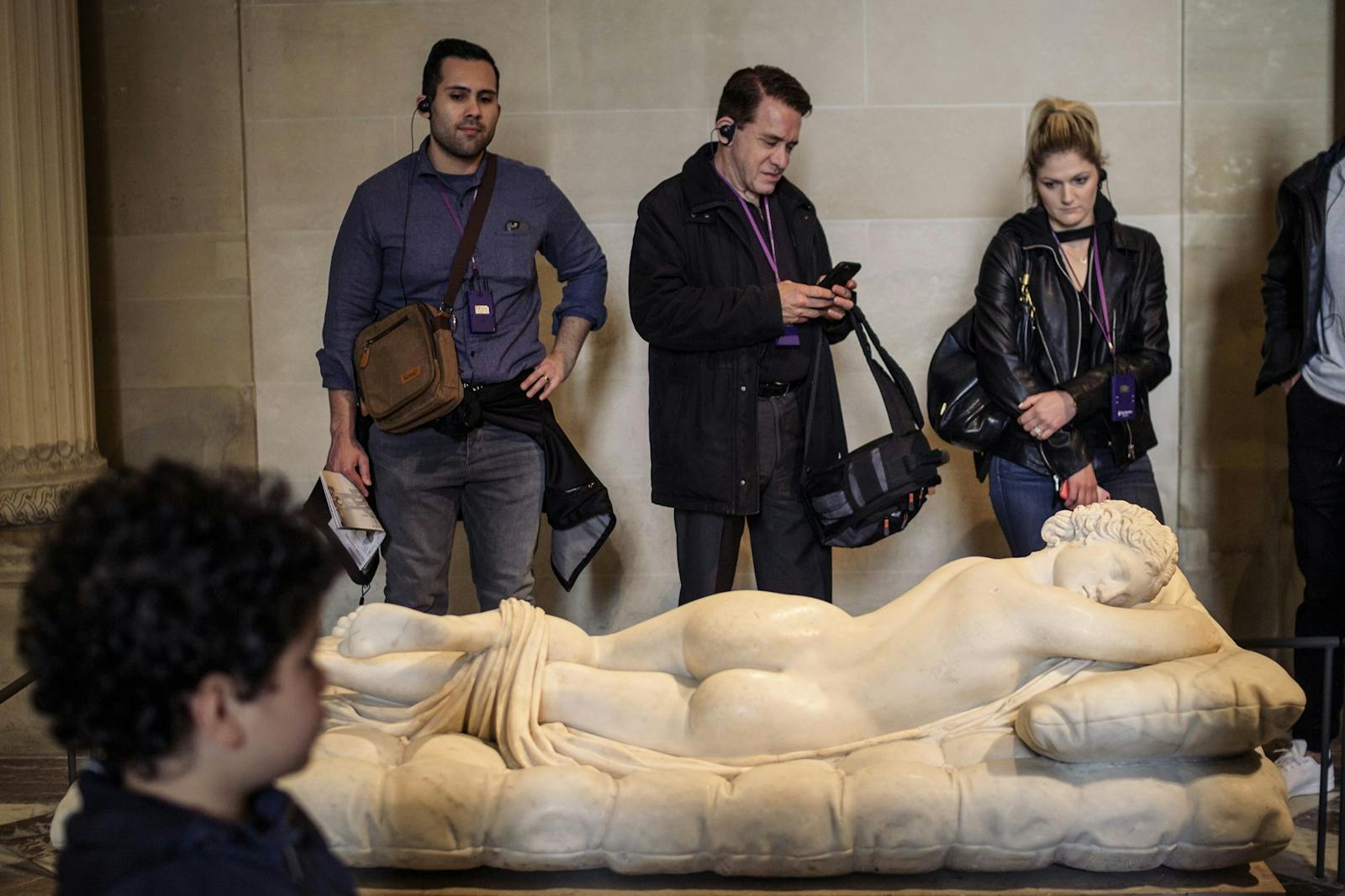 Vieraita tarkastelemassa makavaa veistosta Louvre-museossa