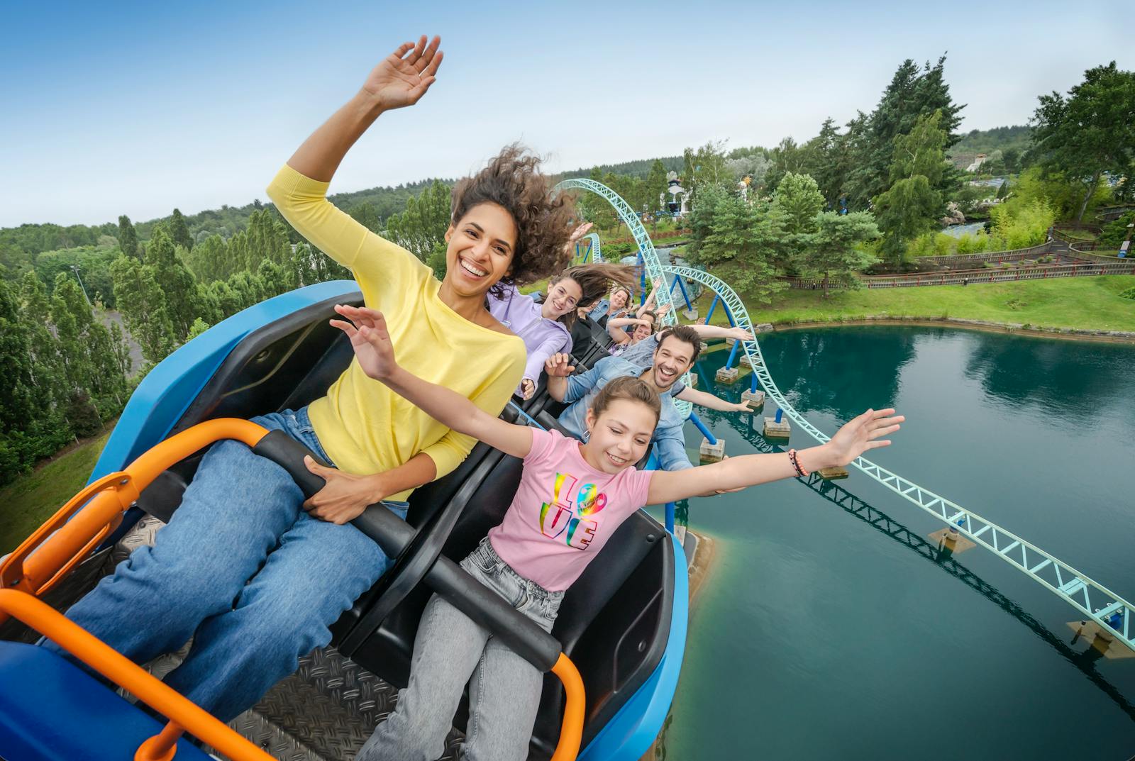 Vizitatori zâmbitori pe un vagon de munte la Parc Astérix