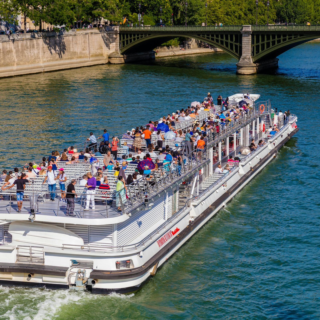 Ein Kreuzfahrtschiff fährt nahe dem Eiffelturm